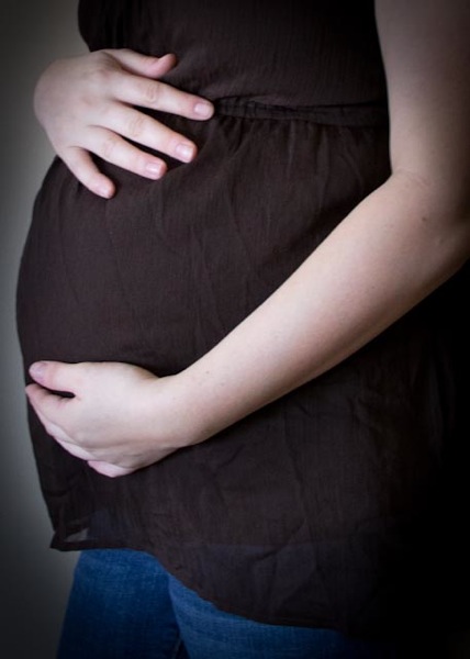 pregnant woman holding stomach