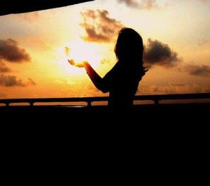 woman in low light lifting hands