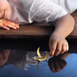 boy looking into reflection in water