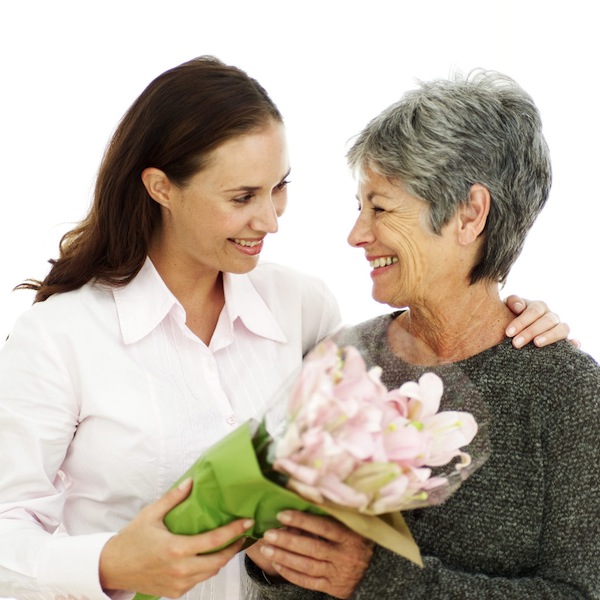 a younger woman giving older woman flowers