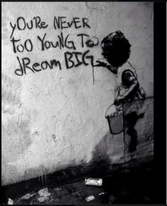 little girl writing on wall dream big