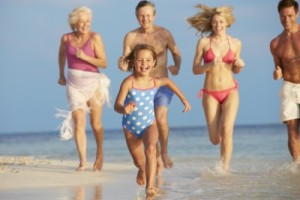 grand parents with family running on beach