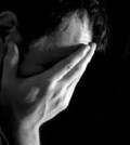 man with hands covering face