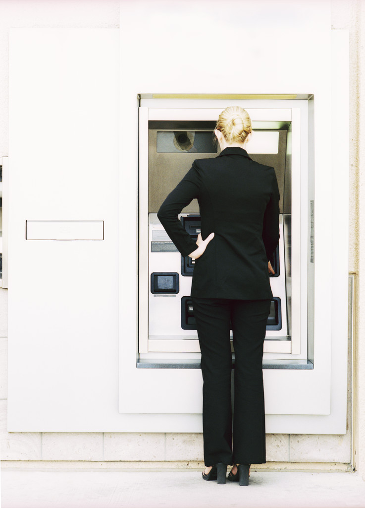 woman standing at atm machine