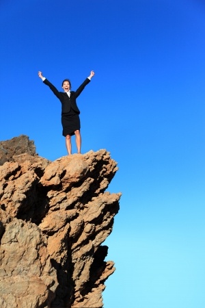 woman standing victoriously on pinacle