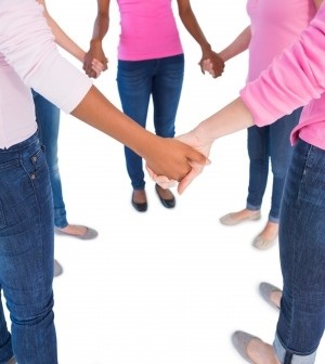 women holding hands dressed in breast cancer pink