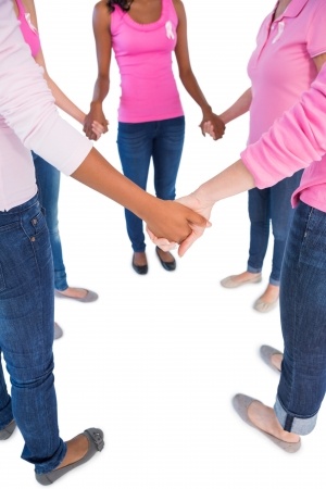 women holding hands dressed in breast cancer pink