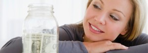 woman looking at jar with money