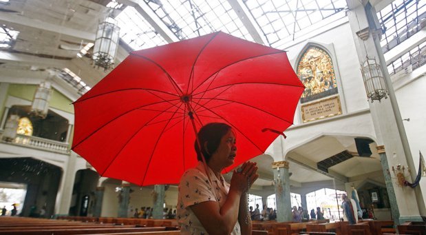 woman praying at church in TACLOBAN CITY