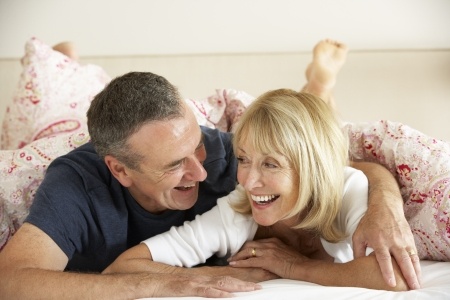 mature couple laughing on bed