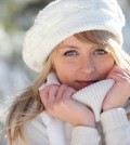 woman in winter holding sweater to face