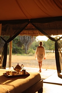 woman walking out of camp tent Selous