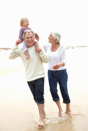 mature couple walking on beach with child