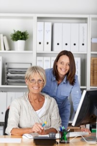 mature woman with younger woman in home office