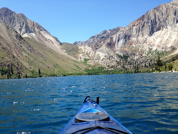 Polly Roethe canoeing lake and mountains in background