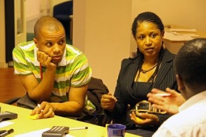 photo of woman and young man sitting with man with calculator and paper work