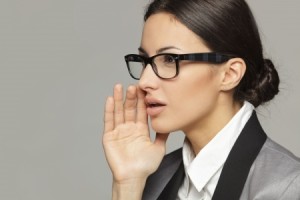 woman speaking with hand to mouth