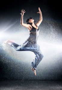 woman dancing in the rain with arms raised