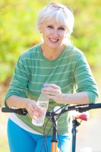 mature woman leaning on bike with water bottle