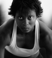 a woman with determined expression in position to run a race