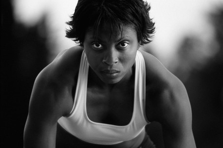 a woman with determined expression in position to run a race