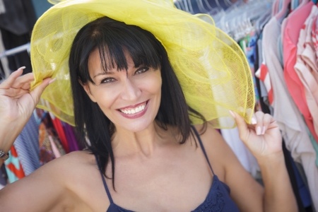 smiling mature woman tying on hat