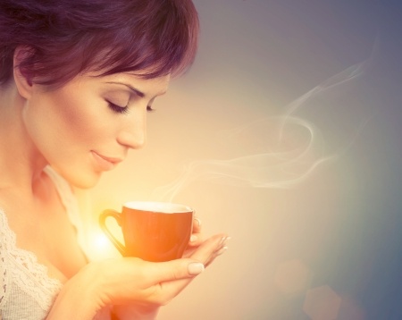 attractive woman with warm cup of tea/coffee in hands