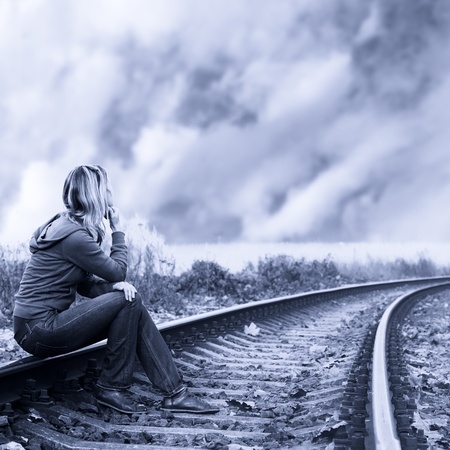 sad woman sitting on traintracks