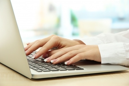 woman typing on laptop keyboard