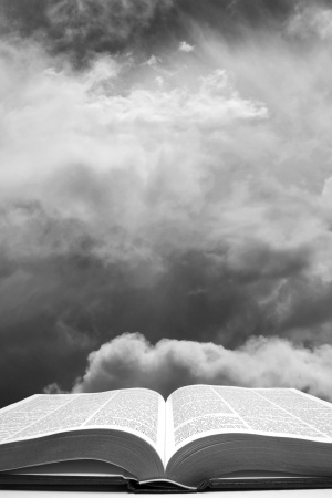 Bible with stormy skies in background