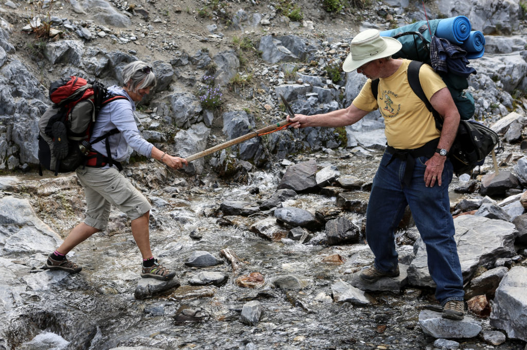 This pic, taken by Marv Knox, is Bob Young extending his antique climber's ax to help Kathy Young cross a creek on the Hurricane Trail.