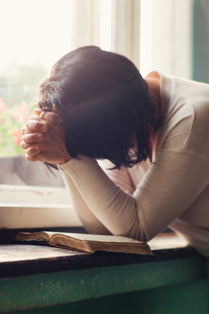 woman reading her bible and praying