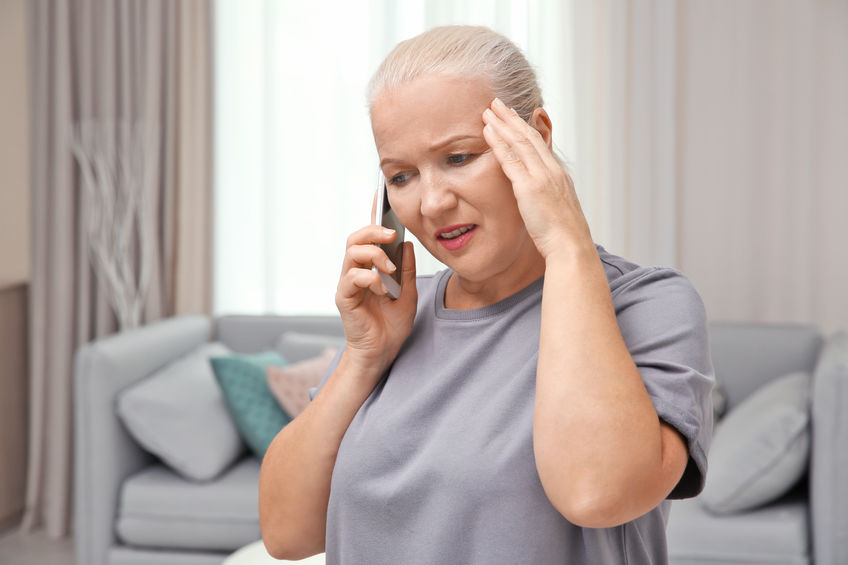 Senior woman speaking on cell phone at home