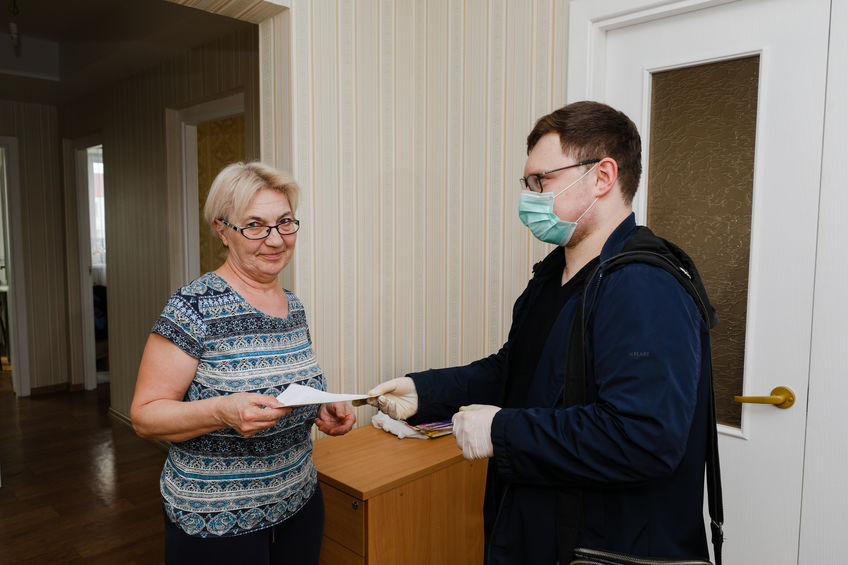 MINSK, BELARUS – February 25, 2020:  social worker volunteer helps old woman coronavirus